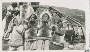 Image of Four little Eskimo [Inuit] girls eating, in furs